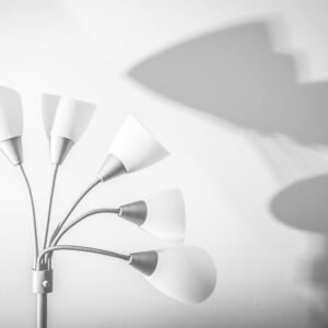 Stylish floor lamp with elegant shadows on a white wall, showcasing minimalism.
