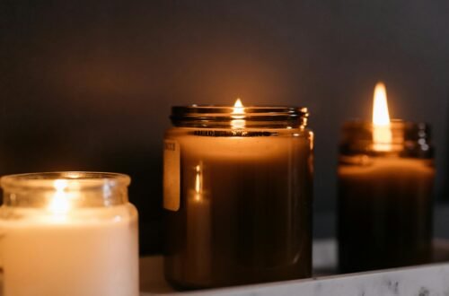 A close-up of burning candles in glass jars creating a warm ambiance.